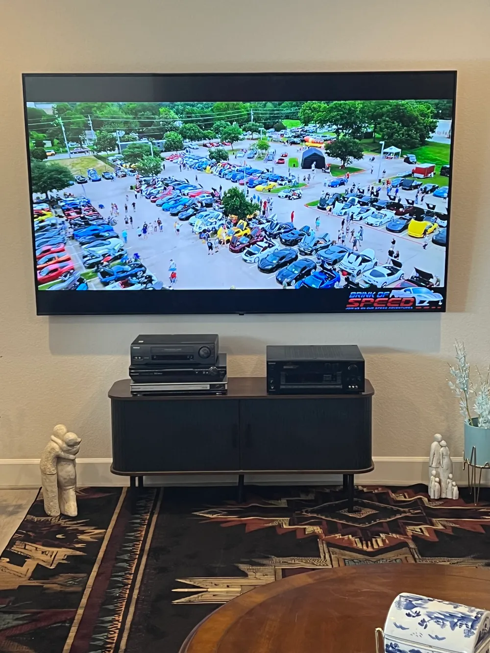 A large flat screen television mounted on a living room wall with the cables concealed, installed by I Hang Flat Screens